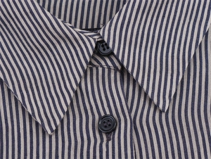 Detailed macro view of striped linen blend shirt collar with neat buttons and fine texture