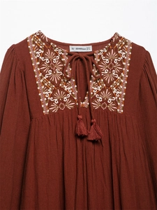 Detail of bohemian embroidery and tassel drawstrings on a vintage cotton-linen dress