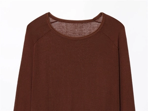 Close-up of the round neckline and raglan sleeve stitching on the linen knit sweater