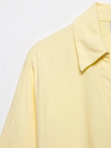 Close-up of the light yellow linen blend shirt showing collar and fabric texture