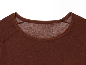Detail of a brown long-sleeve knit top showing the round neckline and raglan sleeve seams