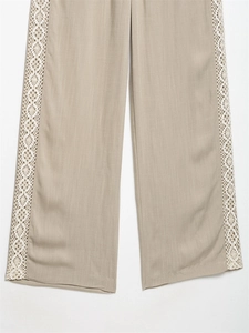 Detailed close-up of khaki linen wide-leg pants with white crochet lace side panels