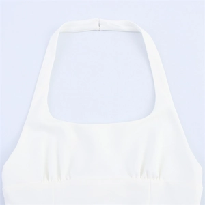 Detail of white halter neck top featuring elegant pleats and neckline buckle closure