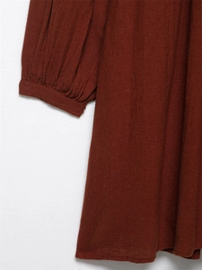 Detailed macro view of brick red cotton linen fabric with pleated cuffs on dress