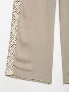 Detail showing the white crochet lace trim on khaki linen wide leg trousers for women
