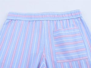 Detail of striped casual shorts showing elastic waistband and horizontal striped back pocket