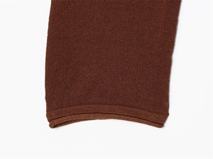 Close-up of dark brown knit fabric showing detailed ribbed cuff texture and fine stitching