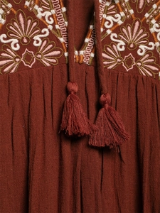 Detailed close-up of embroidery and tassels on an ethnic style v-neck mini dress