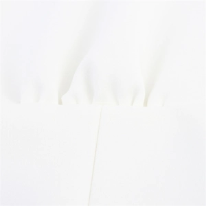 Macro detail of white halter top showing pleated fabric texture and horizontal stitching