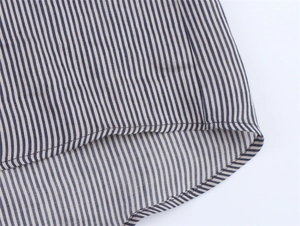 Detailed close-up of blue and white striped linen blend fabric with neat sewing stitching
