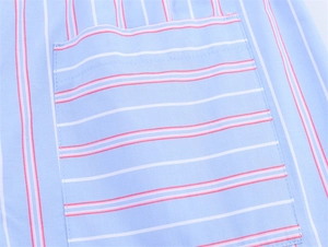 Detail of light blue striped shorts with pink and white patterns and a stitched pocket