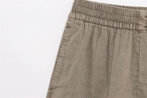 Detailaufnahme des elastischen Bunds an einer khakifarbenen Leinenhose mit feinen Nähten