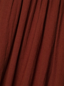 Close-up of rust-red cotton linen fabric showing vertical pleated texture and weave detail