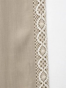 Close-up of natural beige fabric with white crochet lace embroidery for the casual set
