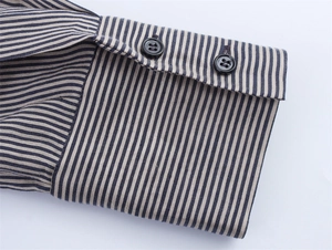 Detailed close-up of navy blue striped shirt sleeve with two black buttons and fabric texture