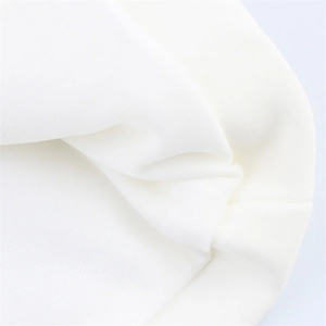 Close-up of the fine white knit fabric texture and premium material of the halter top