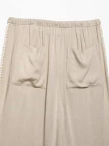Detail view of elastic waist and lace trim on beige linen casual pants for women