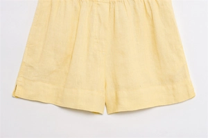 Detail der hellgelben Leinen-Shorts mit elastischem Bund und Seitenschlitz-Struktur