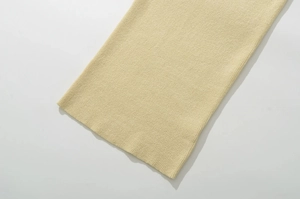 Gros plan sur la texture de la maille fine et le tissage jaune doux de la robe