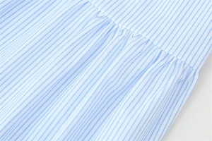 Détail du tissu à rayures bleues et blanches avec plis élégants et texture smockée fluide