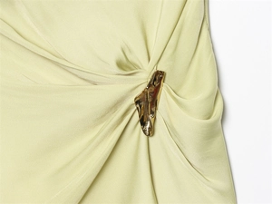 Dettaglio del tessuto in raso liscio con fibbia in metallo dorato e pieghe eleganti