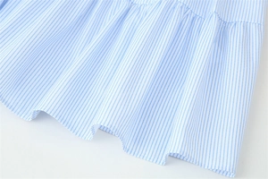 Gros plan sur la texture du tissu à rayures bleu clair et blanc et les coutures de l'ourlet