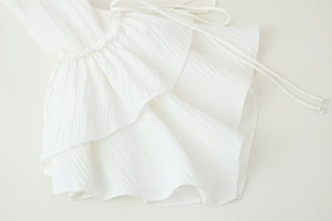 Detail of white chiffon blouse with elegant ruffled layers and pleated texture