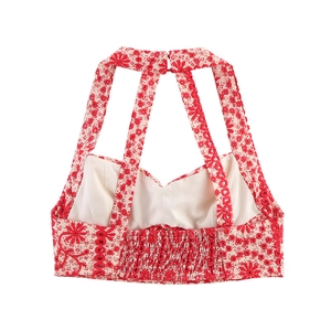 Detail of red floral halter top showing bohemian crochet straps and embroidery trim