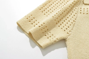 Détail de la robe en maille crème avec motifs ajourés et finition du bord de manche