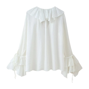 Detailed view of white chiffon blouse showing ruffled neckline and pleated texture