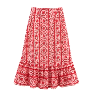 Detailed close-up of the red and white lace embroidery and tiered ruffle hem on the skirt
