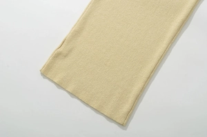 Gros plan sur la texture en maille côtelée beige et la finition lisse d'une robe