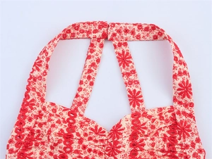 Detail of red floral halter neck top with white eyelet embroidery and button closure