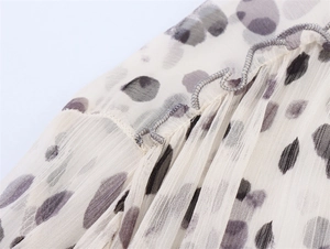 Close-up of pleated chiffon fabric with purple animal print and delicate lettuce edges