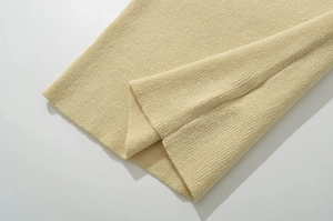 Gros plan détaillé sur la maille texturée d'une robe de printemps beige ajustée