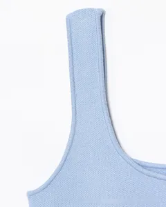 Dettaglio della maglia fine su un gilet azzurro con trame di lavorazione a maglia