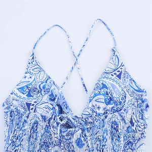 Detail of blue paisley print dress with V-neckline, cross straps and smocked chest area