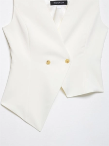 Detail of white asymmetric sleeveless vest showing deep V-neck and two-button closure