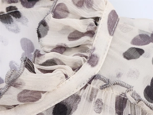 Macro detail of chiffon shirt neckline with ruffled edges and abstract floral prints