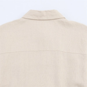 Close-up of beige linen fabric texture and collar detail on a long waist dress