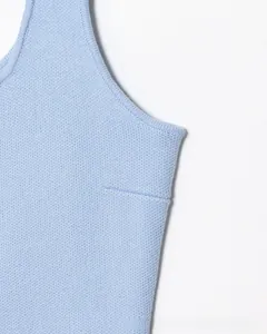 Dettaglio del gilet in maglia azzurro che mostra la trama fine e le cuciture rinforzate