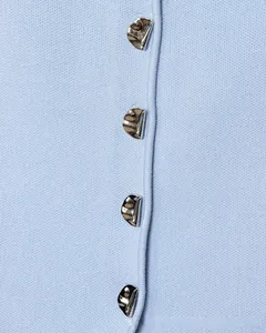 Dettaglio del cardigan in maglia celeste con bottoni in metallo argento irregolari