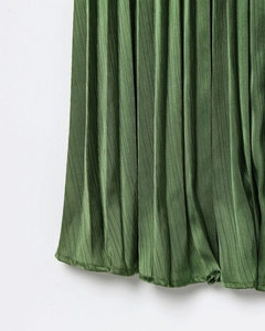 Détail du tissu plissé vert foncé montrant la texture soyeuse lisse et le beau drapé