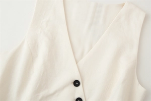 Close-up of beige V-neck vest with textured fabric and stylish black buttons
