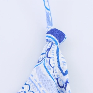 Detail of blue ethnic floral print fabric with halter neck tie on a straight dress
