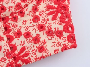 Detail of red broderie anglaise embroidery on floral fabric for women's two-piece set