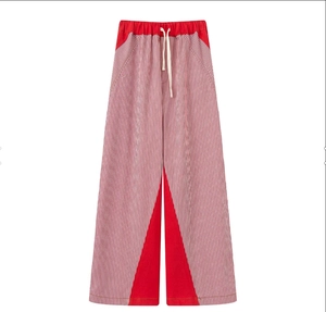 Detail of red and white vertical striped wide-leg pants with elastic drawstring waist