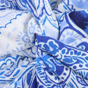 Detail of blue and white paisley print fabric with a knot design and woven texture