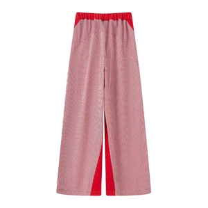 Detail of red and white striped wide-leg pants featuring geometric contrast panels
