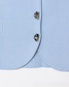 Dettaglio del tessuto in maglia blu con bottoni metallici argento strutturati